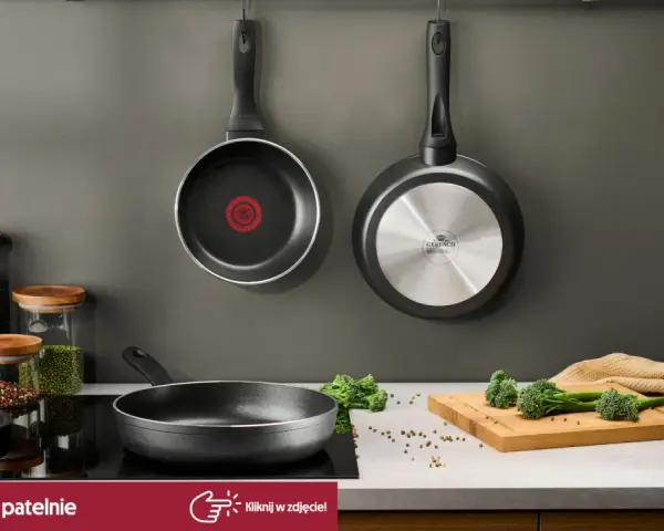 Dwie patelnie wiszące, jedna z logo Tefal, druga Gerlach. Na blacie patelnia, słoiki z makaronem i przyprawami, deska z brokułami. Czy patelnie Tefal można myć w zmywarce? Sprawdź!