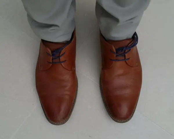 Scarpe marroni eleganti con lacci blu nascosti, un modo per allacciare le scarpe senza far vedere i lacci.