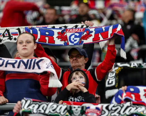 Kibice Górnika Zabrze na meczu z GKS Katowice. Widać szaliki z napisem "Górnik Zabrze" i herbem klubu.