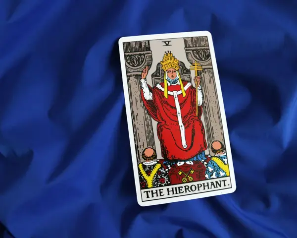 Karta Tarota "The Hierophant" na niebieskim tle. Symbolizuje tradycję, duchowość i przewodnictwo.