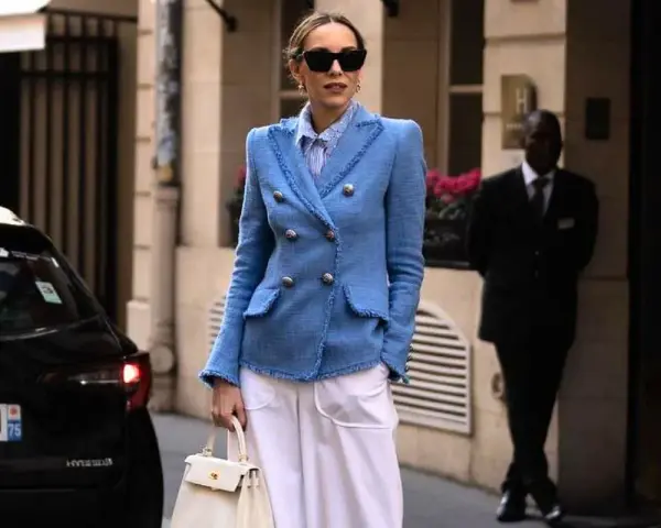 Elegancka kobieta w niebieskiej marynarce i białych spodniach, gotowa na sesję lookbook.