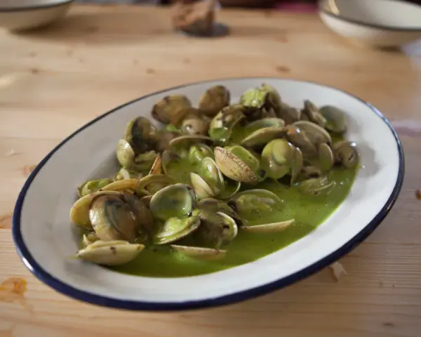 Deliciosas almejas en salsa verde, un plato que invita a saborear el mar.