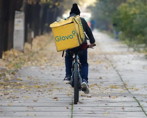 Kurier na rowerze z żółtą torbą Glovo jedzie ależsza. Chyba glovo nie działa, bo wygląda na zagubionego.