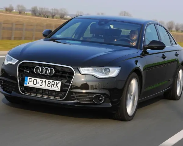Czarne Audi A6 C7 3.0 TDI Biturbo w ruchu drogowym.