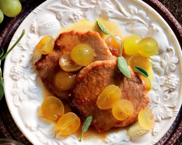 Scaloppine al vino bianco con uva dorata e salvia, un piatto succulento e profumato.