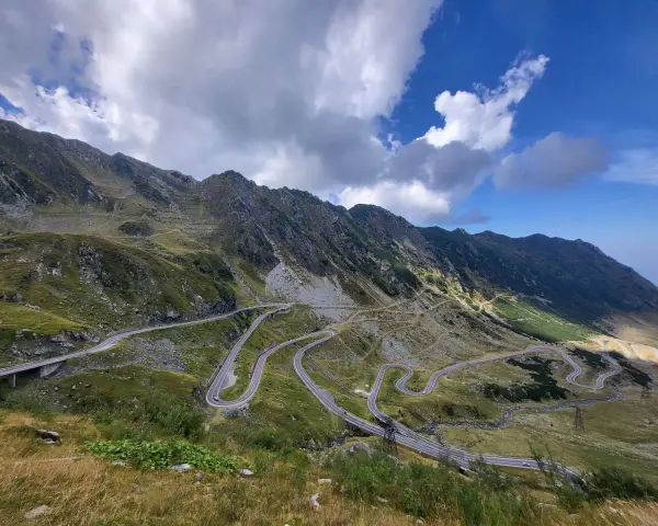 Wężykująca droga w górach Rumunii, idealna na wyprawę motocyklem. Widok zapiera dech w piersiach!
