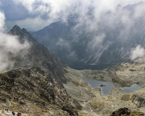 Widok na szlak turystyczny i jeziora w Tatrach, w oddali majaczy schronisko pod Rysami.