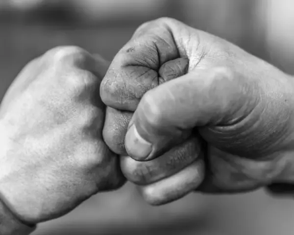 Zwei Fäuste stoßen zusammen, ein Zeichen von Solidarität und Verbundenheit.