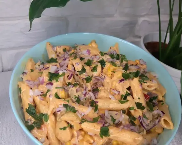 Penne z sosem gyros, kukurydzą i czerwoną cebulą, posypane natką pietruszki. Pyszna sałatka gyros z makaronem.