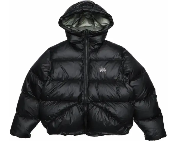 Piumino nero Stussy con cappuccio e logo bianco sul petto. Perfetto per affrontare il freddo con stile.