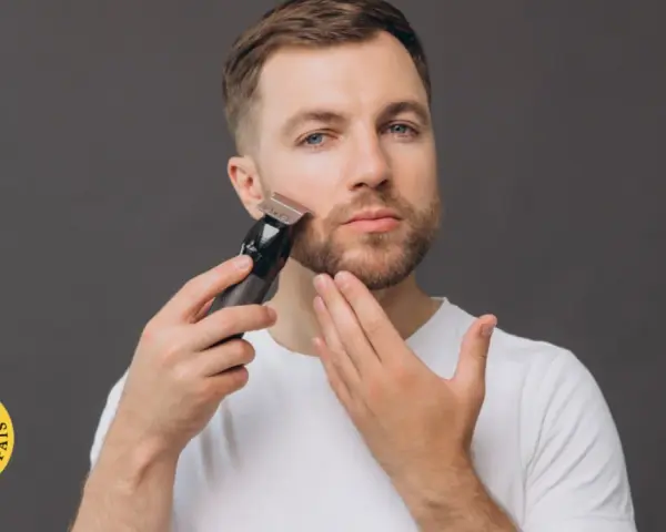 Hombre con barba usando una recortadora para perfilar su rostro. El accesorio "Testado por el país" aparece en la esquina inferior izquierda.