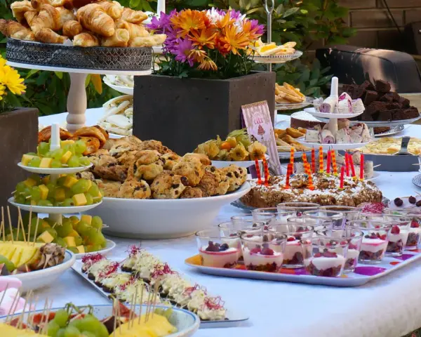 Vielfältige Brunch Ideen: Croissants, Scones, Obstspieße, Brownies und süße Desserts in Gläsern laden zum Genießen ein.