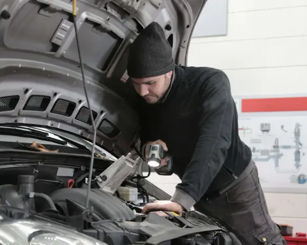 Mechanik bada silnik, szukając objawów uszkodzenia przegubu zewnętrznego.