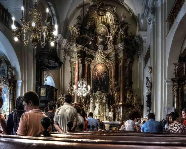 Wnętrze kościoła z bogato zdobionym ołtarzem. Ludzie siedzą w ławkach, słuchając kazania. Czy to czas na gorzkie żale?