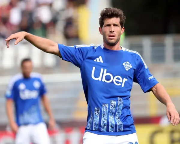 Sergi Roberto, con camiseta azul del Como, señala con el dedo en un partido.