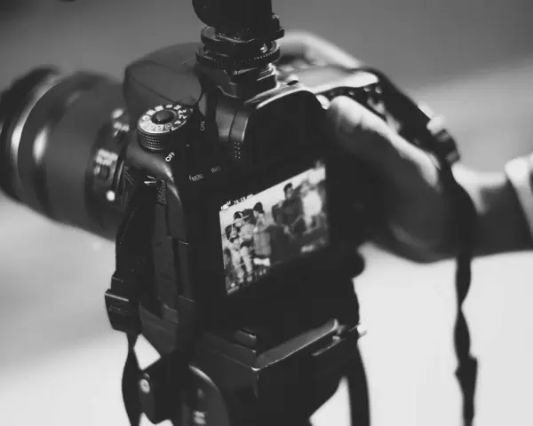 Dłoń trzyma aparat, gotowa do uchwycenia chwili. Może to być moment z życia gwiazdy, który trafi na okładkę, albo praca paparazzi w akcji.
