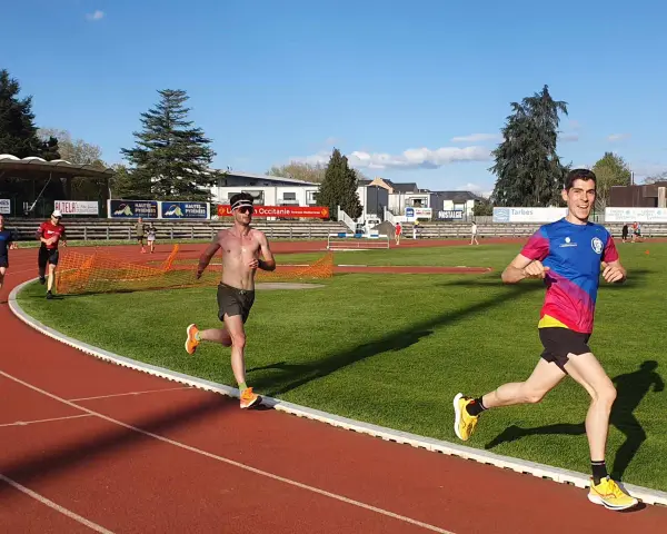 Coureurs sur piste, s'entraînant pour savoir combien de jours de repos avant une compétition. Le soleil brille sur la piste d'athlétisme.