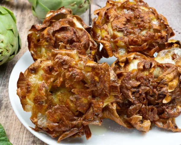 Un piatto di croccanti carciofi alla giudia, dorati e salati, pronti per essere gustati.
