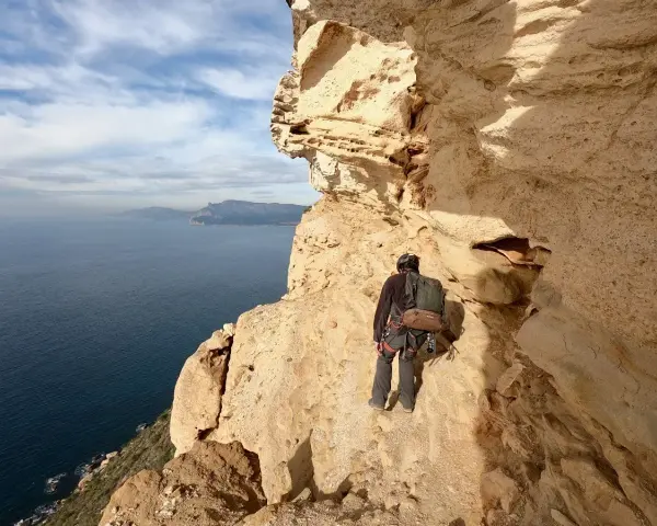 Grimpeur au **Cap Canaille**, face à la mer Méditerranée, prêt pour l'aventure sur les falaises calcaires.