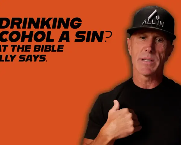 A man in a black t-shirt and "ALL IN" hat discusses if drinking alcohol is a sin, referencing what the Bible says.