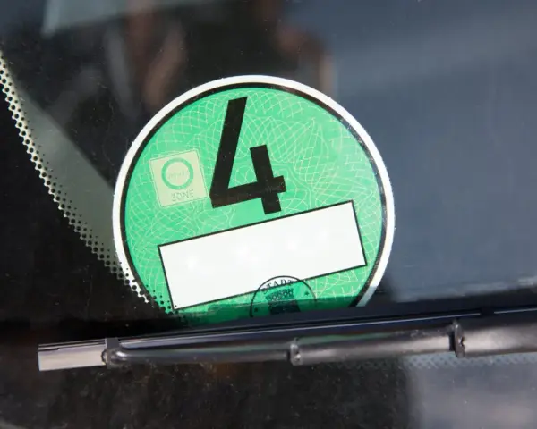 Grüne Umweltplakette mit der Nummer 4. Diese zeigt, welche Schadstoffklasse ist gut für die Umweltzone.