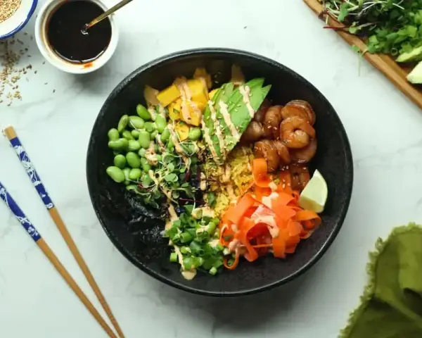 Kolorowy poke bowl z krewetkami, awokado, edamame i marchewką. Idealny przepis na szybki i zdrowy posiłek.