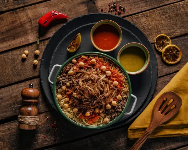 Kushari, narodowe danie kuchni egipskiej, z makaronem, ryżem, soczewicą, ciecierzycą, sosem pomidorowym i chrupiącą cebulką.