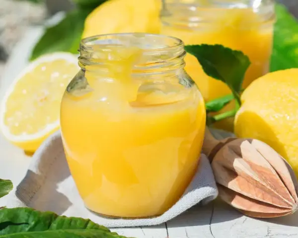 Un pot de lemon curd onctueux, prêt à être dégusté. Une recette simple pour un délice acidulé.