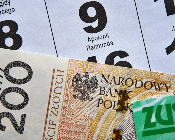 200 zł i zielona karta ZUS na tle kalendarza z datami. Może to być numer świadczenia ZUS.