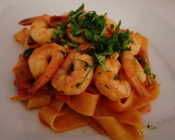 Pappardelle z krewetkami i pomidorkami, posypane świeżą natką pietruszki. Pyszne danie, które zachwyci każdego smakosza.