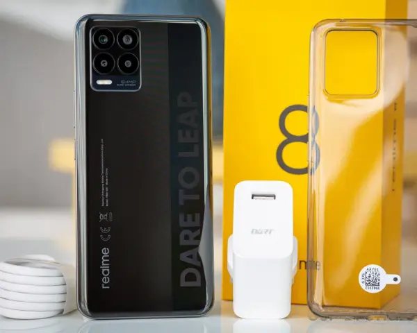 Zestaw z telefonem realme 8: czarny smartfon, ładowarka, kabel i przezroczyste etui.