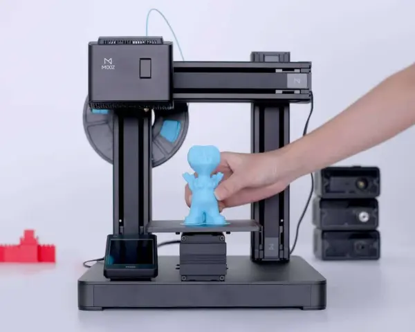 Drukarka 3D MOOZ tworzy niebieską figurkę. Zastanawiasz się, ile prądu zużywa drukarka 3D?