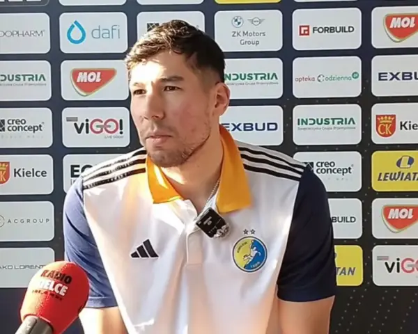 Daniel Dujshebaev w koszulce z herbem klubu, przed ścianką sponsorską z logo "Industria Kielce".