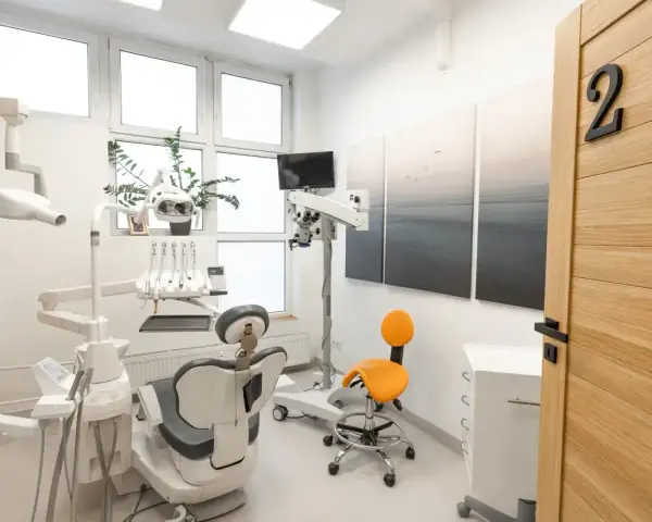 Nowoczesny gabinet stomatologiczny z fotelem, mikroskopem i drzwiami z numerem 2.