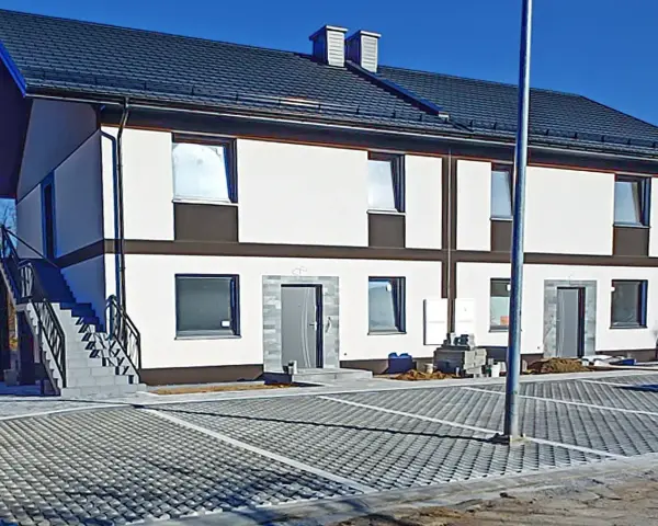 Nowy bliźniak w stanie deweloperskim, gotowy do wykończenia. Nowoczesna elewacja, parking z kostki brukowej.