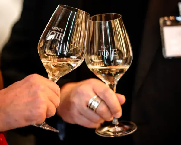 Deux verres de pinot gris "Sainte Joie" levés pour un toast.