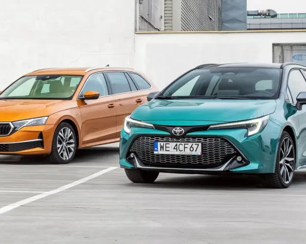 Dwa kombi: pomarańczowa Skoda i zielona Toyota, stojące na parkingu.