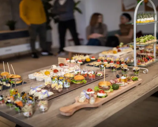 Stół pełen pysznych finger food: mini burgery, koreczki, przekąski w pucharkach. Idealne na imprezę!