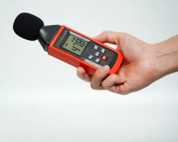 Main tenant une sonomètre pour savoir comment mesurer les décibels dans une pièce. L'appareil affiche 47.8 dB.
