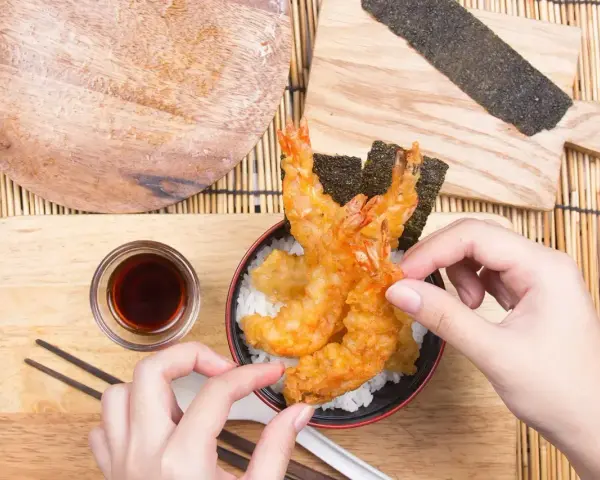 Gotowa tempura jak zrobić? Zobacz, jak pięknie wygląda chrupiąca krewetka w cieście na ryżu, gotowa do podania z sosem.