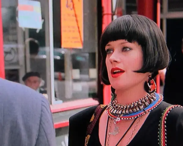 Melanie Griffith in un film, con un taglio di capelli a caschetto e un look audace.