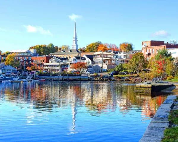 A charming New England harbor town with colorful autumn foliage, perfect for weekend getaways.