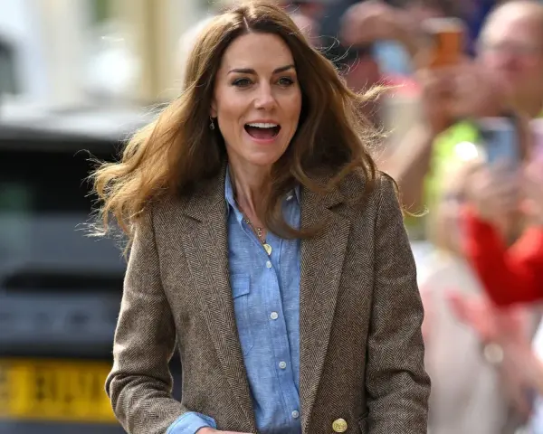 La principessa Kate sorride entusiasta tra la folla, con i capelli mossi dal vento. Le ultime notizie la vedono impegnata in un evento pubblico.