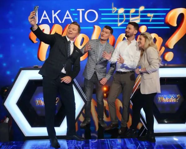 Jaka to melodia obsada robi sobie selfie. Uśmiechnięci uczestnicy pozują na tle scenografii z logotypem programu.