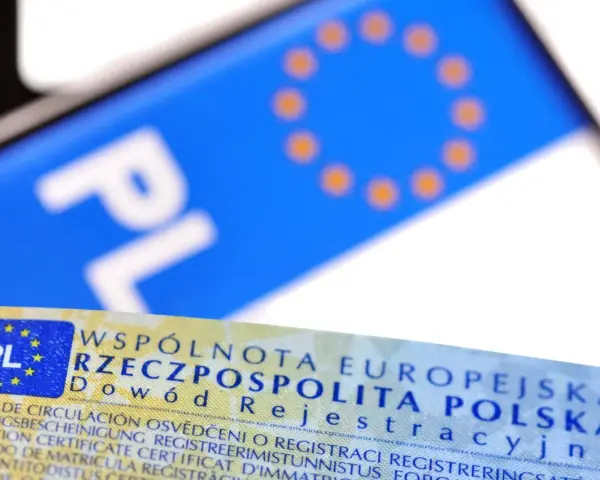 Zbliżenie na polski dowód rejestracyjny i tablicę z literami "PL". Dokument potwierdza legalność pojazdu.