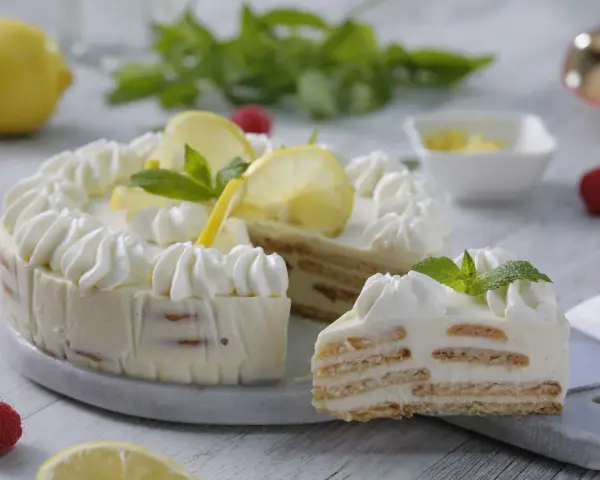 Pastel de limón con crema batida, rodajas de limón y menta.