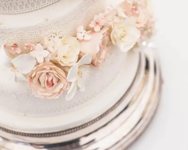 Elegancki tort weselny z różami i koronką. Sprawdź, jaka jest tort weselny cena, by zaplanować idealne przyjęcie.