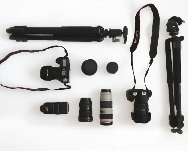 Ensemble d'un appareil photo reflex, d'objectifs, d'un flash et de trépieds, prêt pour une séance photo.