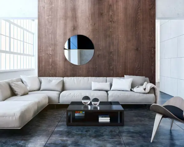 Nowoczesny salon w stylu bauhaus z szarą sofą, drewnianą ścianą i designerskim fotelem.