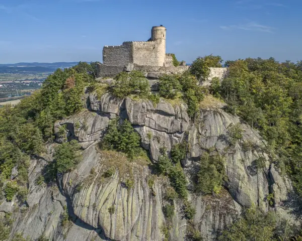 Zamek Chojnik, dawniej znany jako zamek Jelenia Góra, majestatycznie wznosi się na skalistym szczycie, otoczony bujną zielenią lasów.